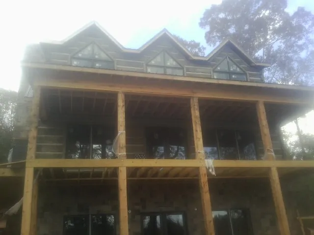 Dormers and porch framing on a large log home under construction — Roof Coating work by our crew in West Park